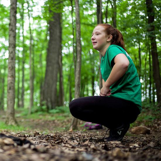 College student seated in the woods